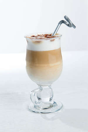 Glass of cold latte coffee topic cocolate cream on isolated white background with dessertsの写真素材