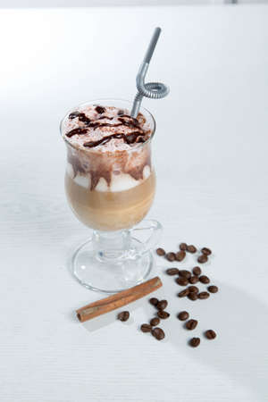 Glass of cold latte coffee topic cocolate cream on isolated white background with dessertsの写真素材