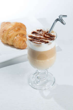 Glass of cold latte coffee topic cocolate cream on isolated white background with dessertsの写真素材