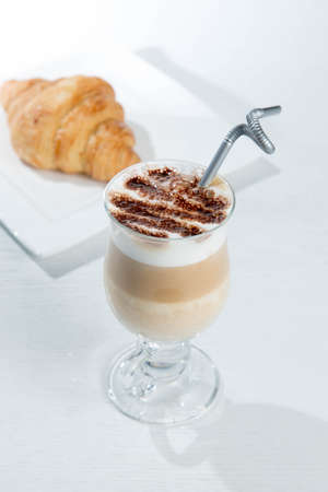 Glass of cold latte coffee topic cocolate cream on isolated white background with dessertsの写真素材