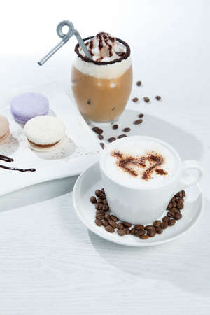 Ice coffee and coffee and nuts near desserts and macaroons in white backgroundの写真素材
