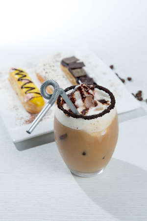 Ice coffee and coffee and nuts near desserts and macaroons in white backgroundの写真素材