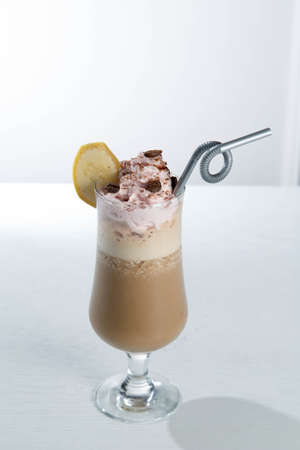 Glass of cold latte coffee topic cocolate cream on isolated white background with bananaの写真素材
