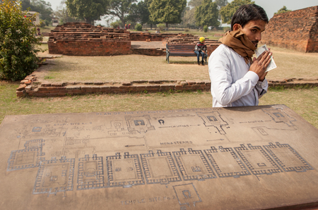 Archaeological heritage of India, ruins of university of Nalanda on February 2, 2014. At a stone with the scheme of excavation, the Indian guide has earned reward.のeditorial素材
