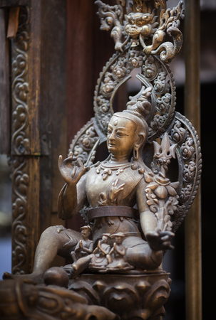 Ancient statue of a bodhisattva of Avalokiteshvara, made of bronze in nevara style, in the Golden Temple, Lalitpur, Kathmandu, Nepal.の写真素材