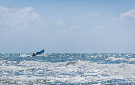 The blue motor boat hurries with rescue team to the aid overcoming big waves of the raging sea.の写真素材