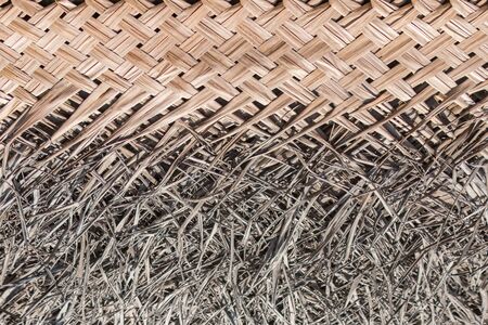 The lodge roof covering in tropics consisting of the dry bound palm leaves. Natural material for the background connected with ecology and natural organic materials.の写真素材