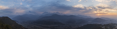 Panoramic view of the snow-covered Himalaya peaks of a mountain ridge Annapurna and the fertile valley of the river of Seti conducting to the city of Pokhara, at sunrise, under the first beams of the sun. Tops Annapurna and Machapuchare are visible.の写真素材