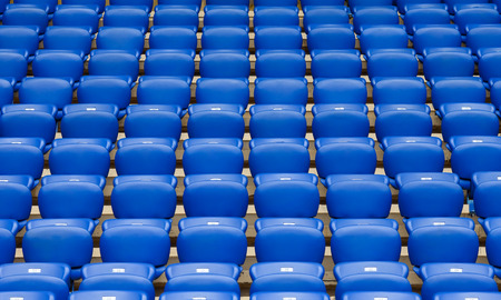 Rows of empty blue plastic chairs on a tribune of stadium going to perspective.のeditorial素材