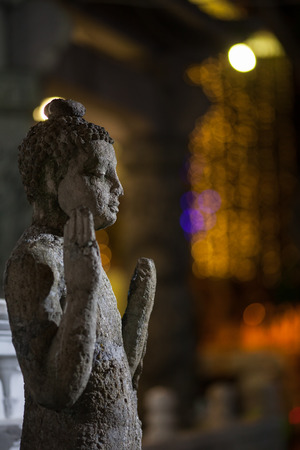 Ancient statue against the background of city lights in a side. Srilankian figure of Buddha with traditional gesture - the hand is raised up and turned by a edge of hand.のeditorial素材