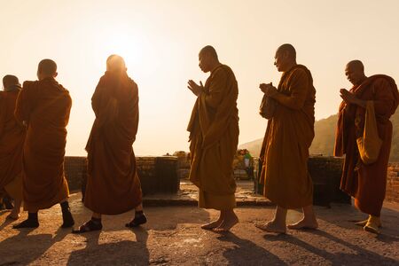 Buddhist monks in traditional Burmese clothes make kora around the sacred place on the mountain of Gridhakuta where Buddha gave the lectures. India. Rajgir, on February 1, 2014のeditorial素材