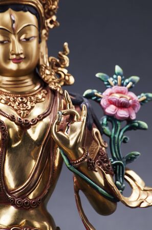 The gilded form of Green Tara with flower, made of metal. Executed in the Tibetan tradition.