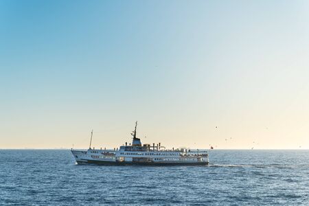 A pleasure ship with turkish flag, floats against the backdrop of emptyness of sea and silhoettes of...