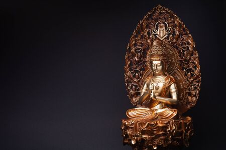 Statue of bronze of Bodhisattva Guan Yin (Avalokiteshvara) sitting in the lotus position, having put hands in knowledge-mudra.の写真素材