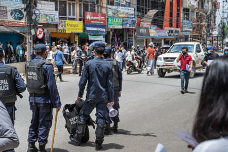 Policeman with loudspeaker standing in time of protests against government corruption and the...