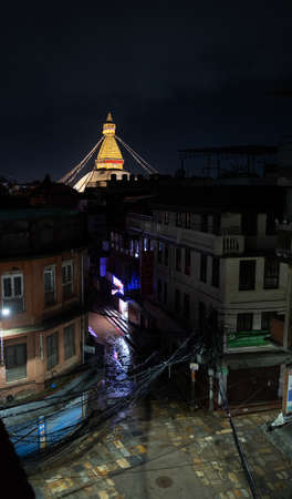 Night view of the brightly lit Boudha stupa, from the roof of a building in one of the city streets, during the rainy season.のeditorial素材