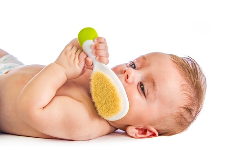 Cute baby holding an hairbrush on whiteの写真素材