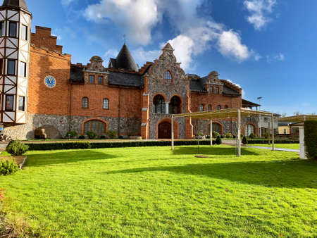 Vintage house in green park with blue cloudy skyの写真素材