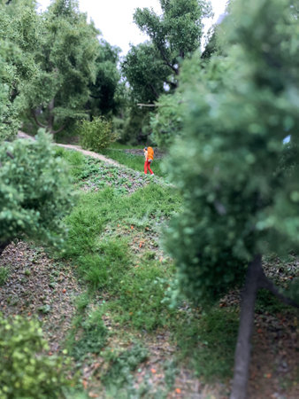 Hike, walk through the green forest. A girl climbing a mountain. Macro photography of a toy forest. High quality photoの写真素材