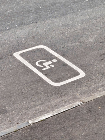 Disabled people parking spot markings. Handicapped symbol. Space Reserved for cars. Reduced Mobility. Russian road sign on Asphalt. View from above. Wheelchair. Accessibility concept. Vertical photoの写真素材