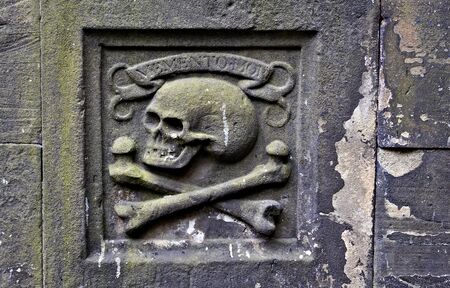 Greyfriars Kirkyard is the churchyard around Greyfriars Kirk in Edinburgh. It is located at the southern end of the historic city center. This photo shows an ornament with skull and bones.の写真素材