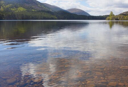 Loch an Eilein is an extremely beautiful sheet of water, reflecting the magnificent pines of Rothiemurchus Forest in which it lies. This photo shows the magnificent landscape.の写真素材