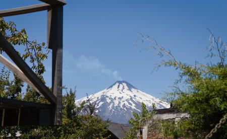 the still active but currently dormant Villarica volcano above the rooftops of Pucon in Chileの写真素材