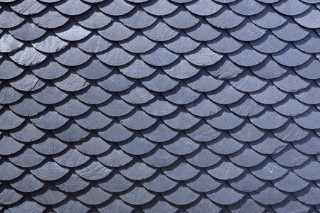 Aged slate roof tiles in close-up