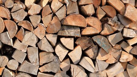 Stack of Wood wood stacked for drying in the woodpile on a green meadow