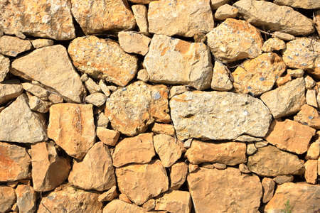 An old yellow brown masonry wall of stones