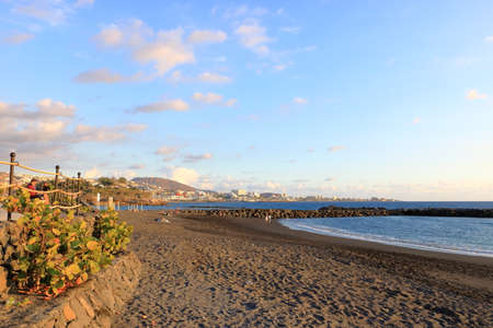 November 20 2021 - Costa Adeje, Tenerife, Spain: Tourists are relaxing and playing on black beachの写真素材