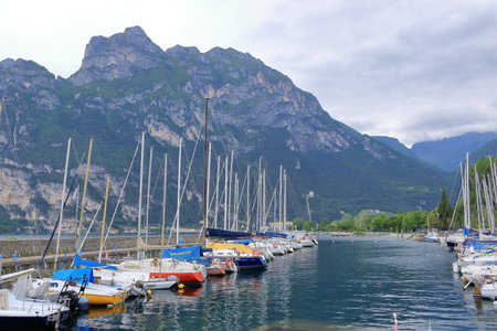 May 19 2023 - Riva del Garda in Italy: people at the port of the town on a cloudy dayのeditorial素材
