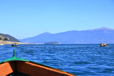 September 13 2023 - Lake Prespa in Albania: Tourists enjoy a boat trip with albanian fishermenのeditorial素材