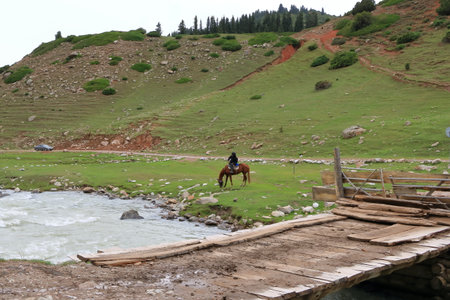 August 28 2023 - Jeti Oguz, Issyk-Kul Region in Kyrgyzstan: locals riding horses in the mountains on a cloudy dayのeditorial素材