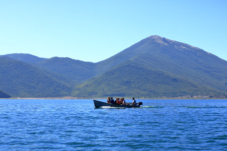 September 13 2023 - Lake Prespa in Albania: Tourists enjoy a boat trip with albanian fishermenのeditorial素材