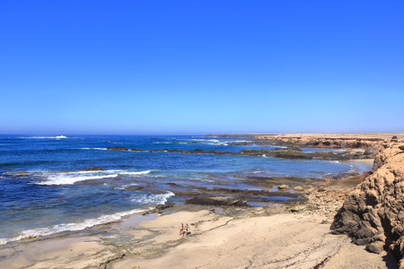 November 19 2023 - Puerto de la Cruz, Jandia, Fuerteventura in Spain: people at the rocky Playa de...