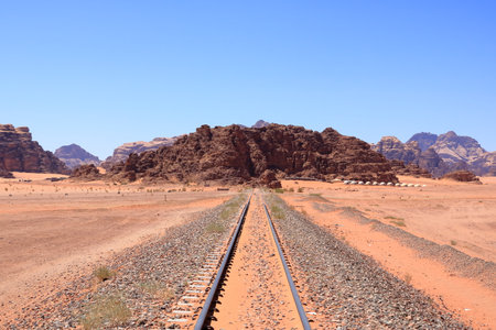Old train rails almost completely covered with desert sand in Wadi Rum in Jordan