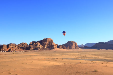 Hot air balloon above the mountains at sunrise in the famous Wadi Rum desert, Jordanの写真素材