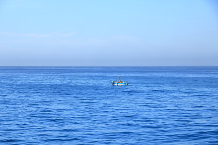 a small fishing boat in the Strait of Gibraltar between Tarifa and Tangierの写真素材