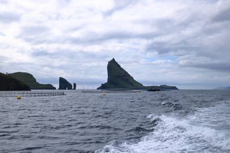 a dramatic view of Drangarnir gate in front of Tindholmur in Vagar island, Faroe Islands, Denmark, north atlantic oceanの写真素材