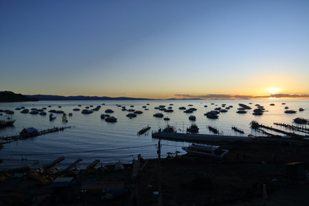 sunset in Copacabana in Bolivia, boats mooring in the bay of the village at the Lake Titicacaの写真素材