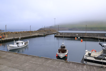 Skalavik, Sandoy Island, Faroe Islands in Denmark - August 27 2025: small harbor on a foggy dayのeditorial素材