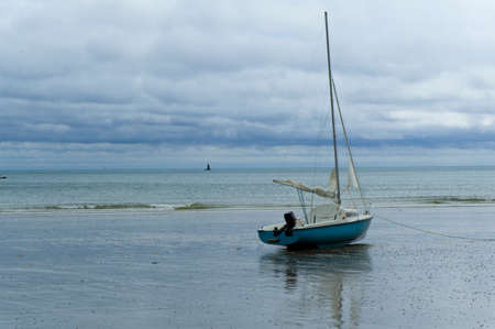 a boat lying aground at low tideの写真素材