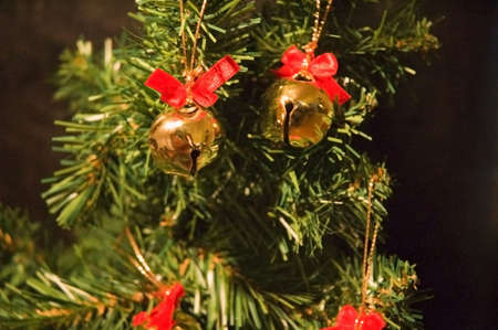 a few bells hanging from a christmas treeの写真素材