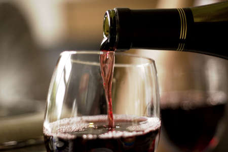 wine pouring from bottle into glassの写真素材