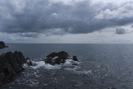 a storm forming over the sea, approaching a rocky coastの写真素材