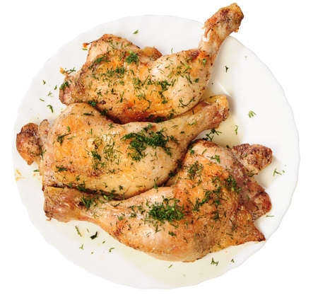 fried chicken legs with a dill from up on white plateの写真素材