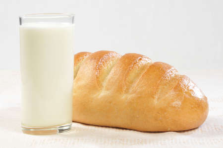 glass of milk or kefir with baton wheaten breadの写真素材