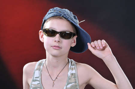portrait of is 10-11 years old boy in a jean cap and sun glassesの写真素材