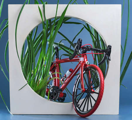 the bike leaves the frame with green grass on a colored blue background, selective focus